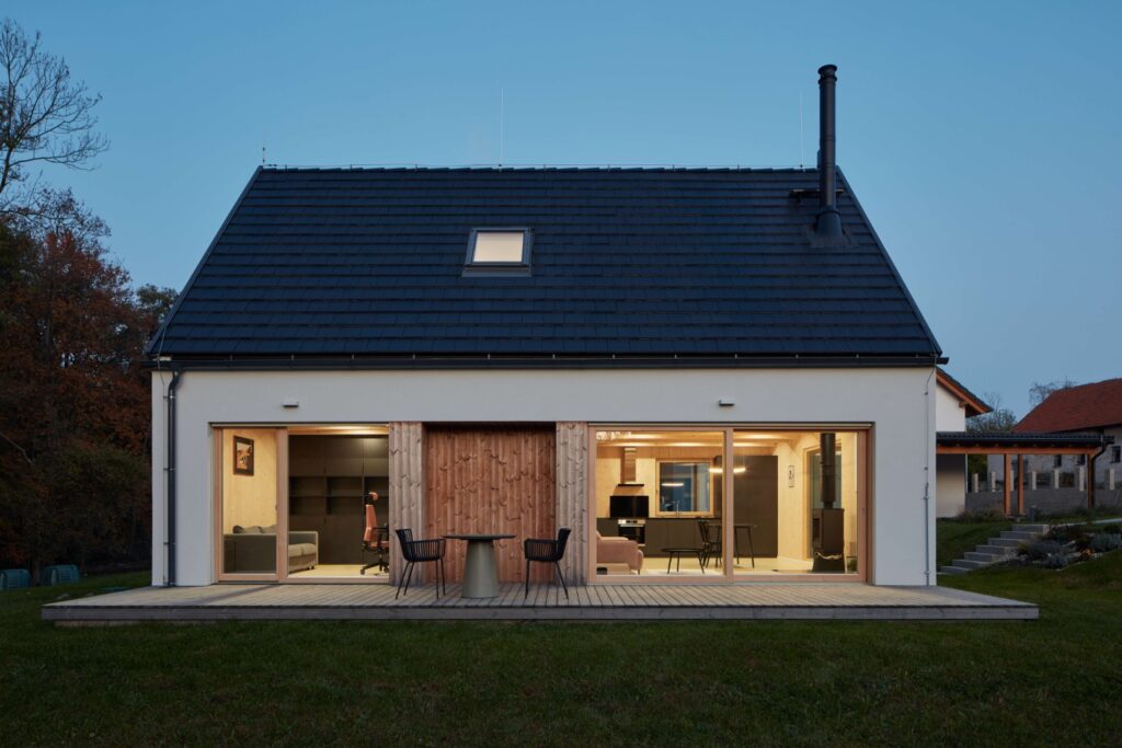 Typový rodinný dům z CLT panelů s prosklenou stěnou a otevřeným obytným prostorem