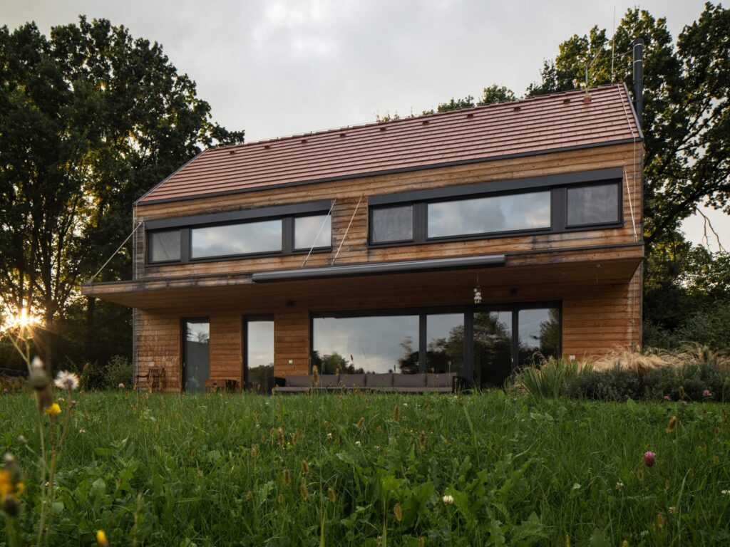 Dvoupodlažní moderní dřevostavba s šikmou střechou a dřevěným obkladem